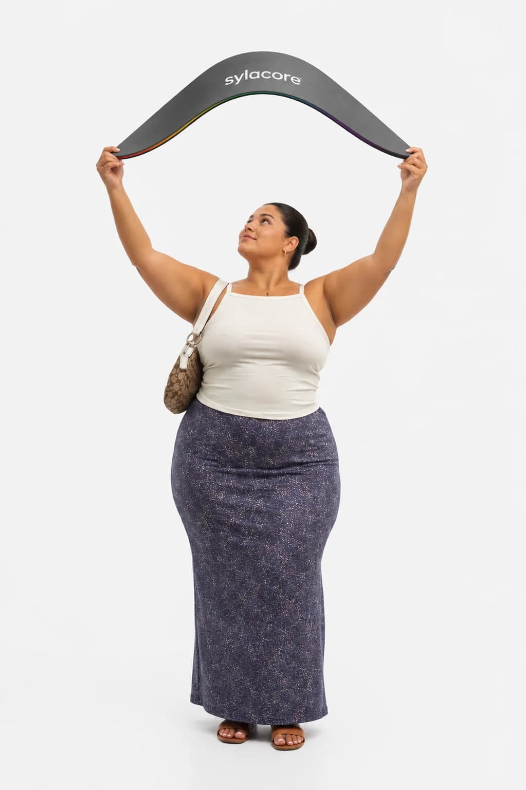 Mujer sosteniendo en alto una plantilla SYLACORE gigante curvada, mostrando su flexibilidad