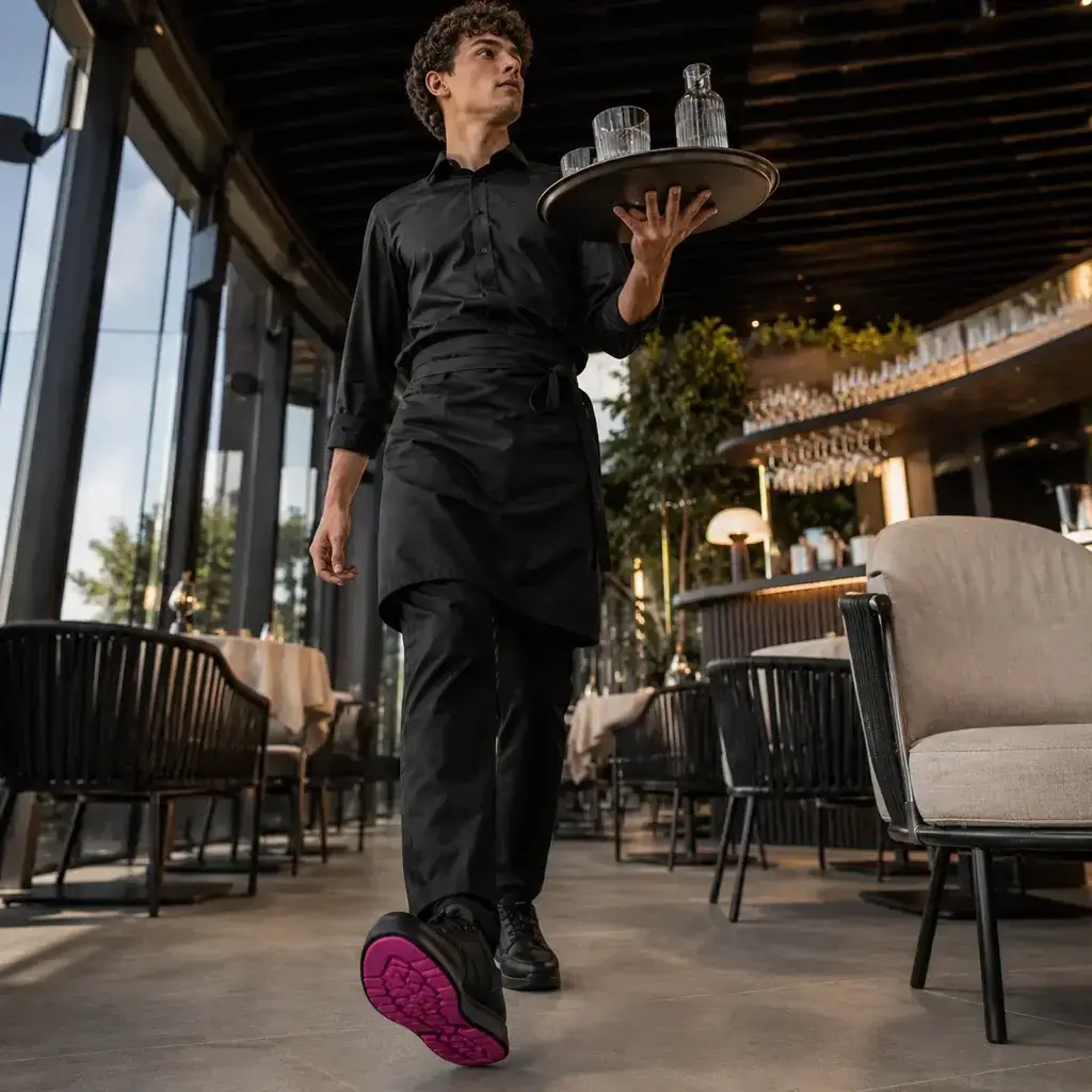 Cambrer amb una safata al saló d'un restaurant, amb plantilles SYLACORE Work Regular